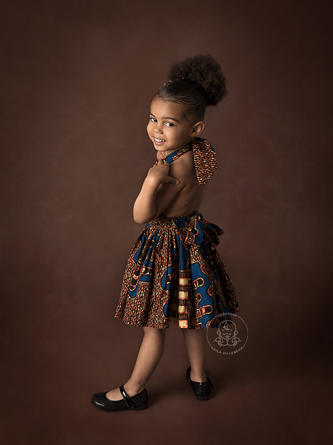 3-årig tjej står och poserar omedvetet i sin afrikanska klänning