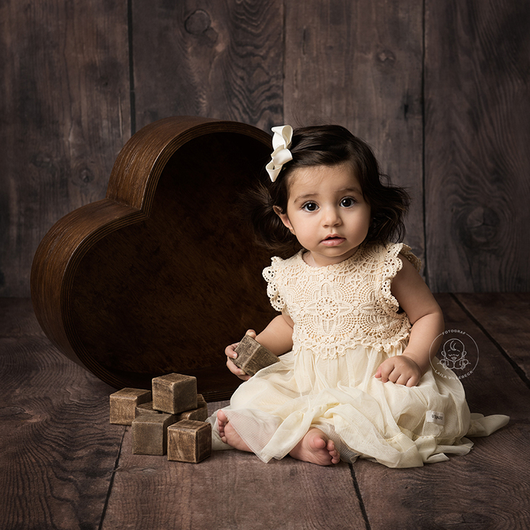 Från en bebisfotografering med en hjärtformad skål i bakgrunden.