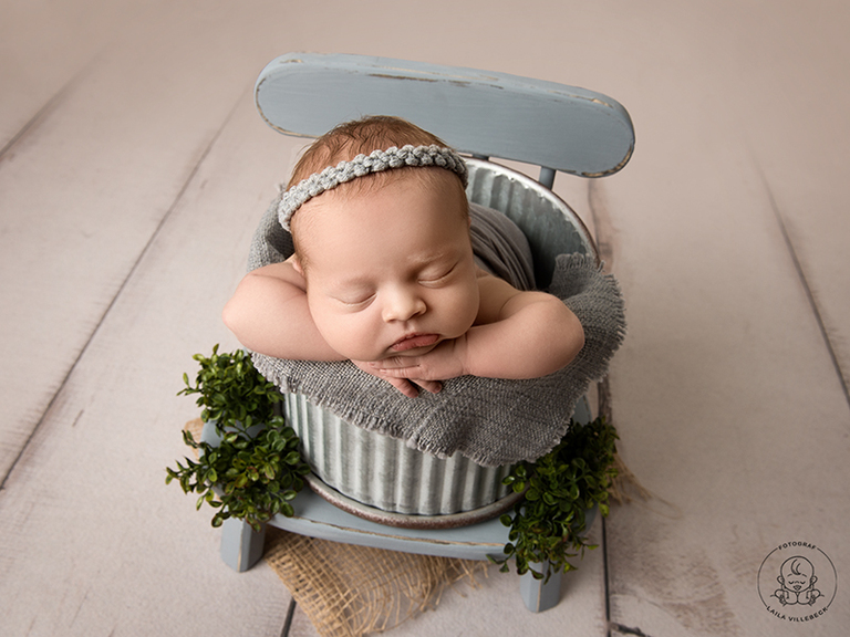 En av mina absoluta favoritbilder från mina nyföddfotograferingar 2022. Nyfödd i bucket pose där hinken står på en liten trästol med väldigt korta ben. Stolen gör att det blir lite mer djup i bilden.