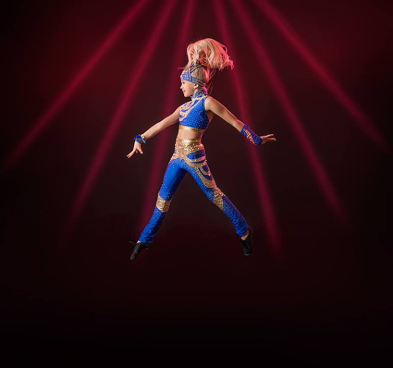 Alicia dansar disco i sin tävlingsdräkt i blått och guld.