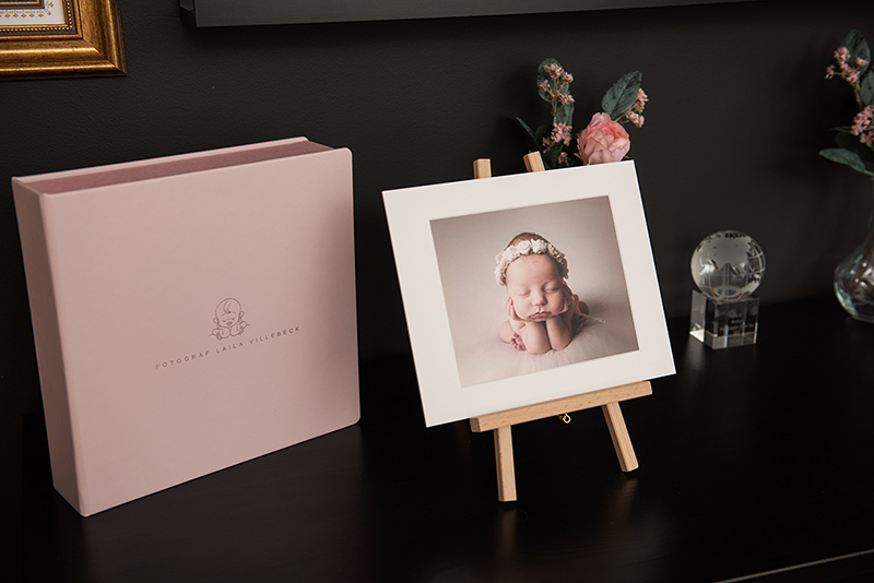 En liten detalj med en bildbox och en bild i passepartout som visas upp på ett staffli, i nyföddfotograf Laila Villebecks studio i Linköping